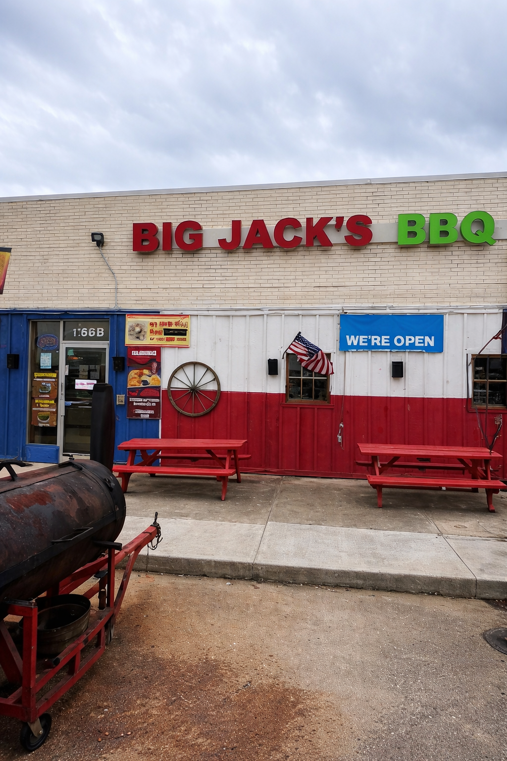 Big Jack's BBQ storefront with red picnic benches, BBQ smoker, and iconic signage